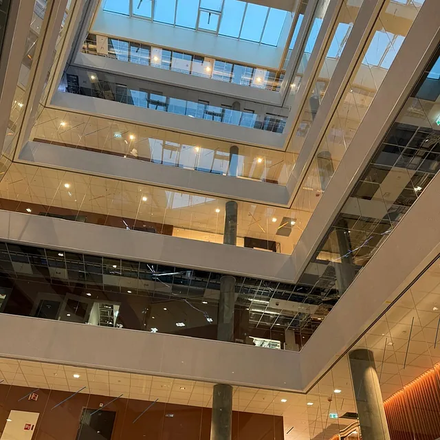 Atrium med flere etasjer og glassfasader.